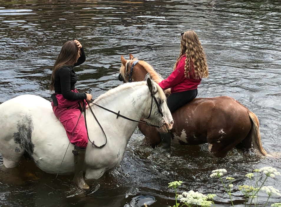 Two girls on horses in Eden River, Appleby Horse Fair